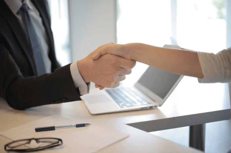 Two personnel having a hand shake.