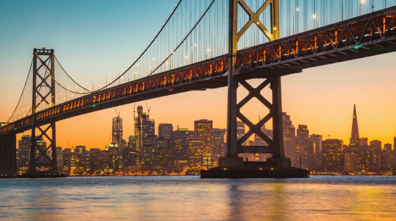 San Francisco–Oakland Bay Bridge at sunset with the city skyline in the background.